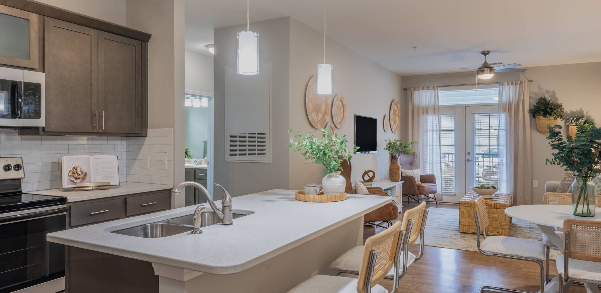 Hawthorne at Leland apartment kitchen with modern appliances, kitchen island, and barstool dining area.