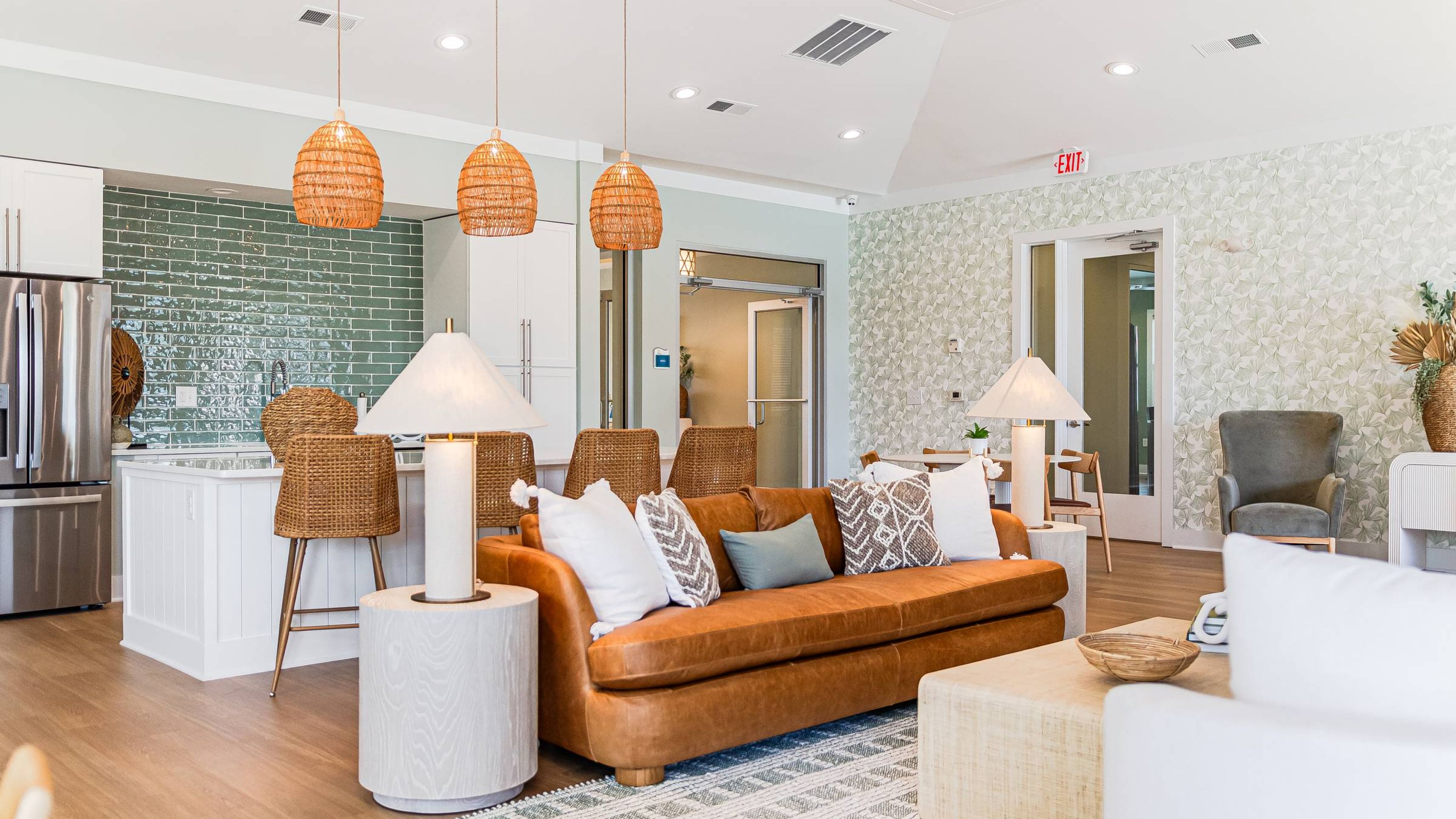 Hawthorne at Leland bright and airy lounge area with leather chairs, a tall bar, and large windows providing natural light.